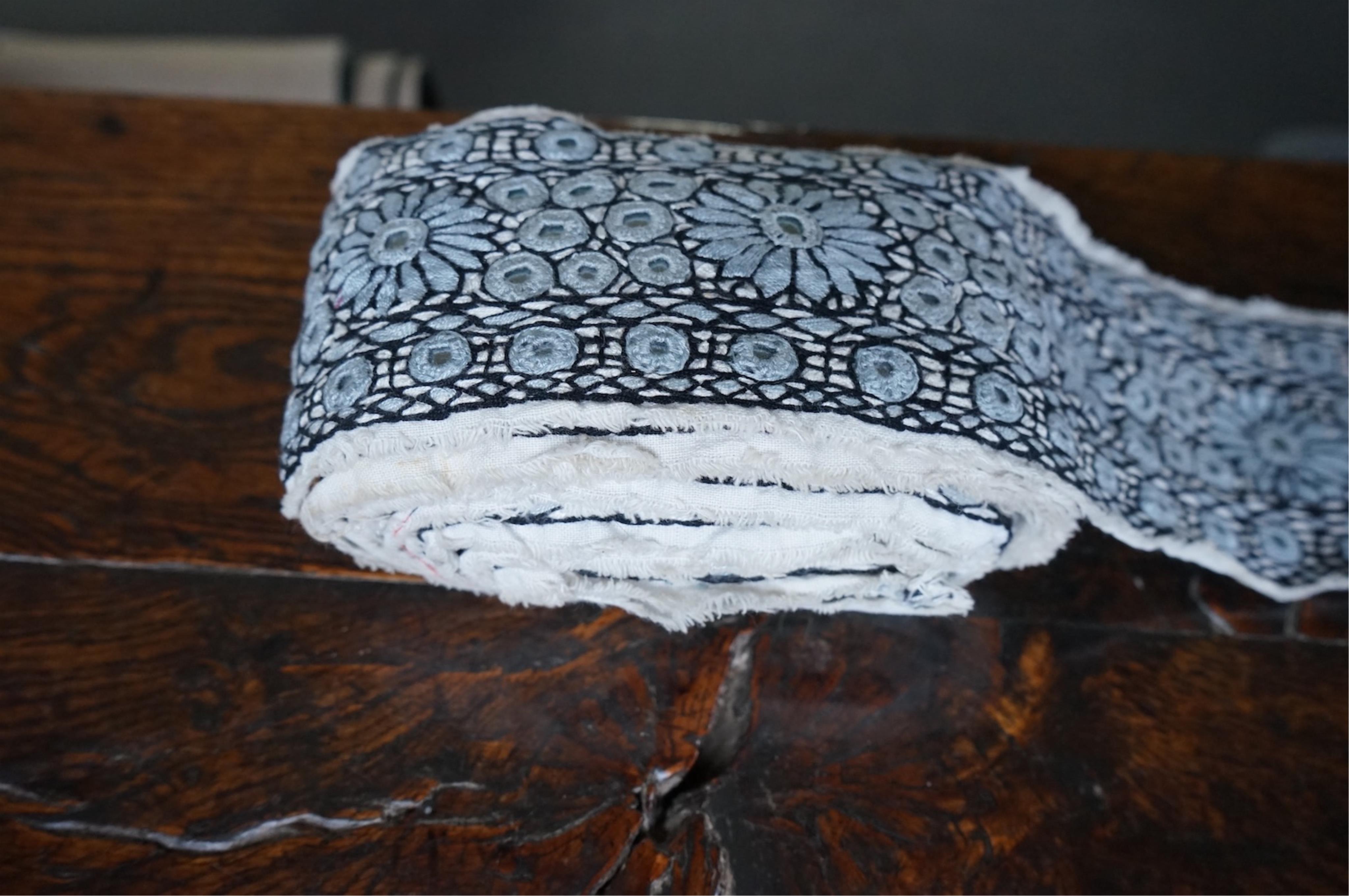 A long narrow length of grey Ikat woven fabric, a roll of Indian mirrored edging, a geometric batik printed length and a woven paisley ‘style’ tasselled stole. (4). Batik 392cm long x 108cm wide., Condition - good, all a